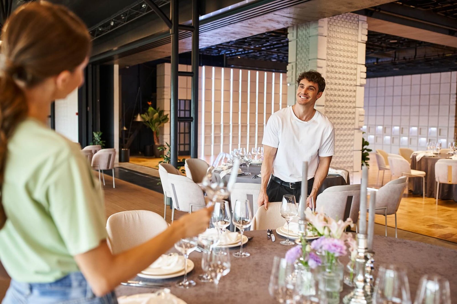 smiling-man-near-festive-tables-looking-at-woman-on-blurred-foreground-banquet-organizers-at-work.jpg